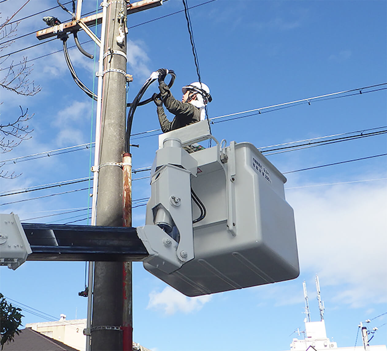 高所の電気工事をする男性の写真